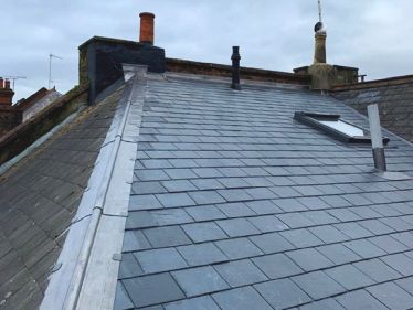 Renewed roof with Spanish slates, code 5 lead ridge & valley and code 4 lead cover flashings after fitting Tyvek breathable felt & timber battens