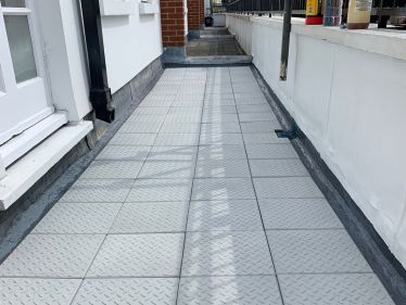 Balcony with new Sika Liquid Plastics covering to the roof and new promenade tiles laid on top in Kensington, West London