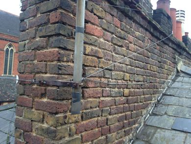 Repaired roof showing renewed chimney pointing with weather struck point joint, new alley soakers & new Spanish slates